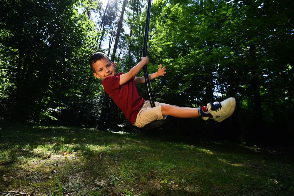 A child enjoying the zip line in the private woodland playground