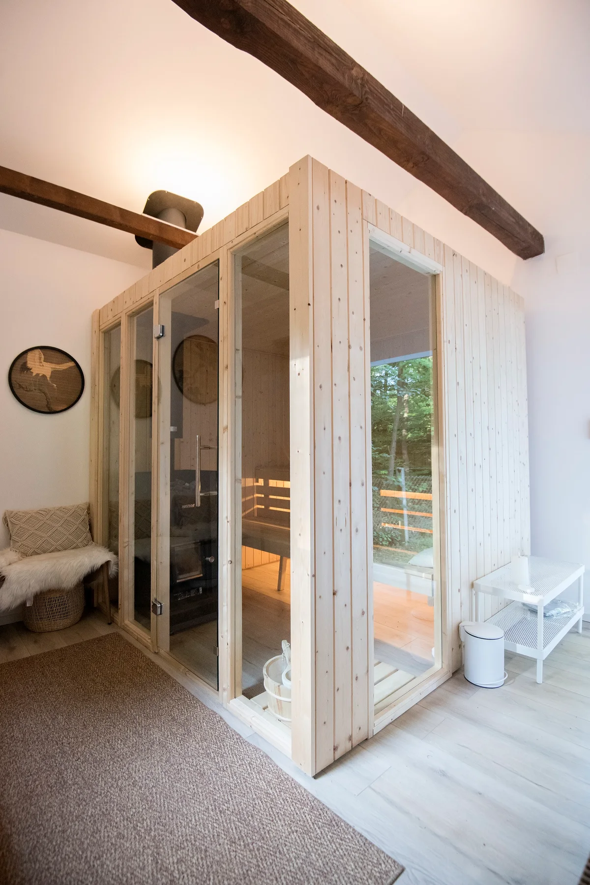 Private sauna with warm timber walls and a view into the forest